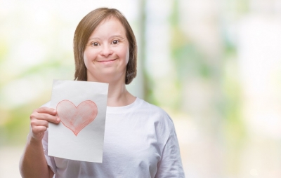 young woman holding a red heart card