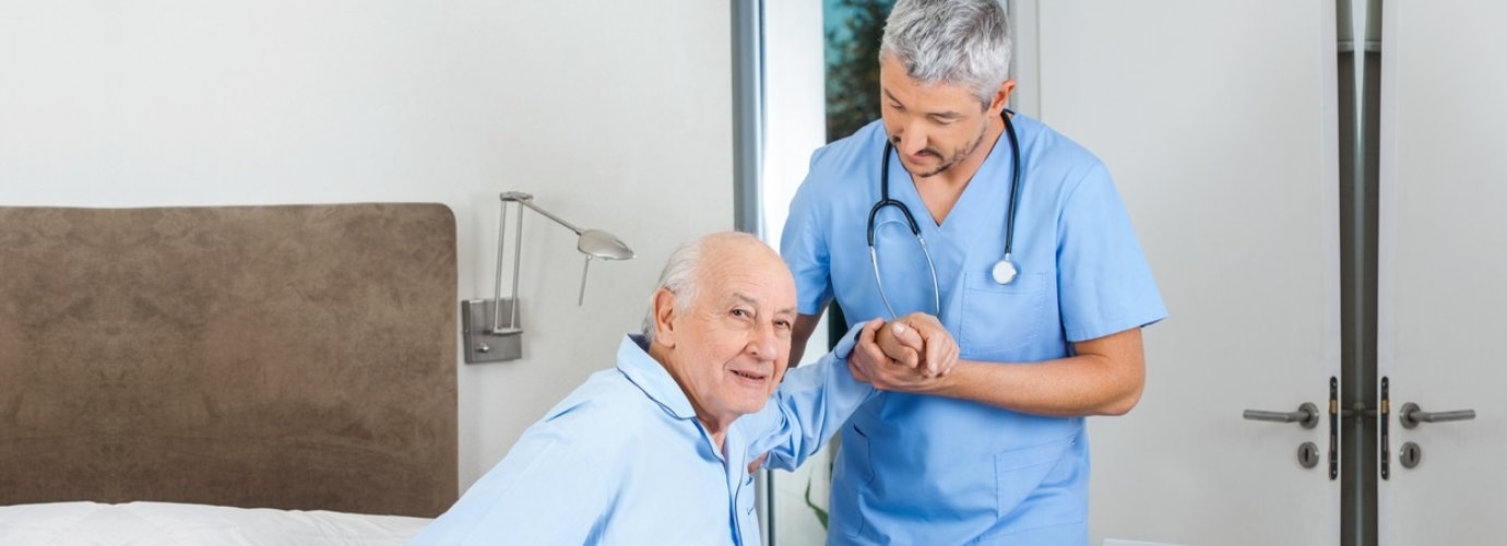 senior man being assisted by male caregiver